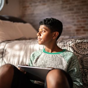 Teenage boy using digital tablet Feed square