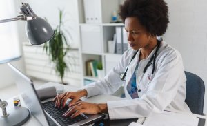 Doctor typing on laptop Website image gallery 1